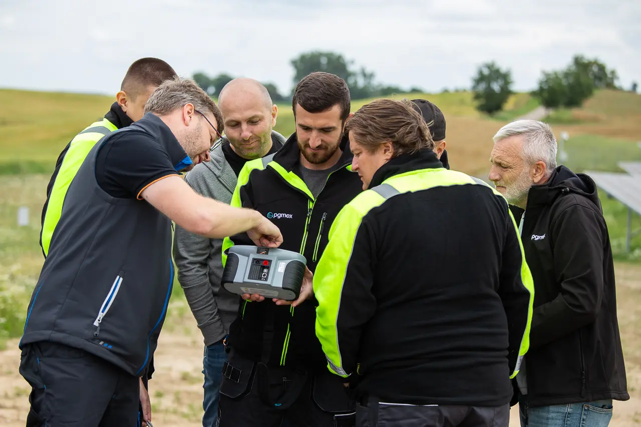 Grupa uczestników poznaje obsługę miernika podczas zajęć w terenie